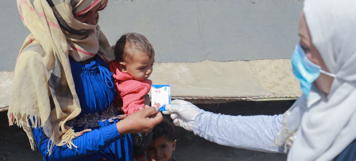 مادری در شهر رقه، سوریه، برای کودکانی که از اسهال رنج می برند، دارو جمع آوری می کند و همچنین دستورالعمل هایی درباره نحوه استریل کردن آب برای محافظت در برابر وبا دریافت می کند.