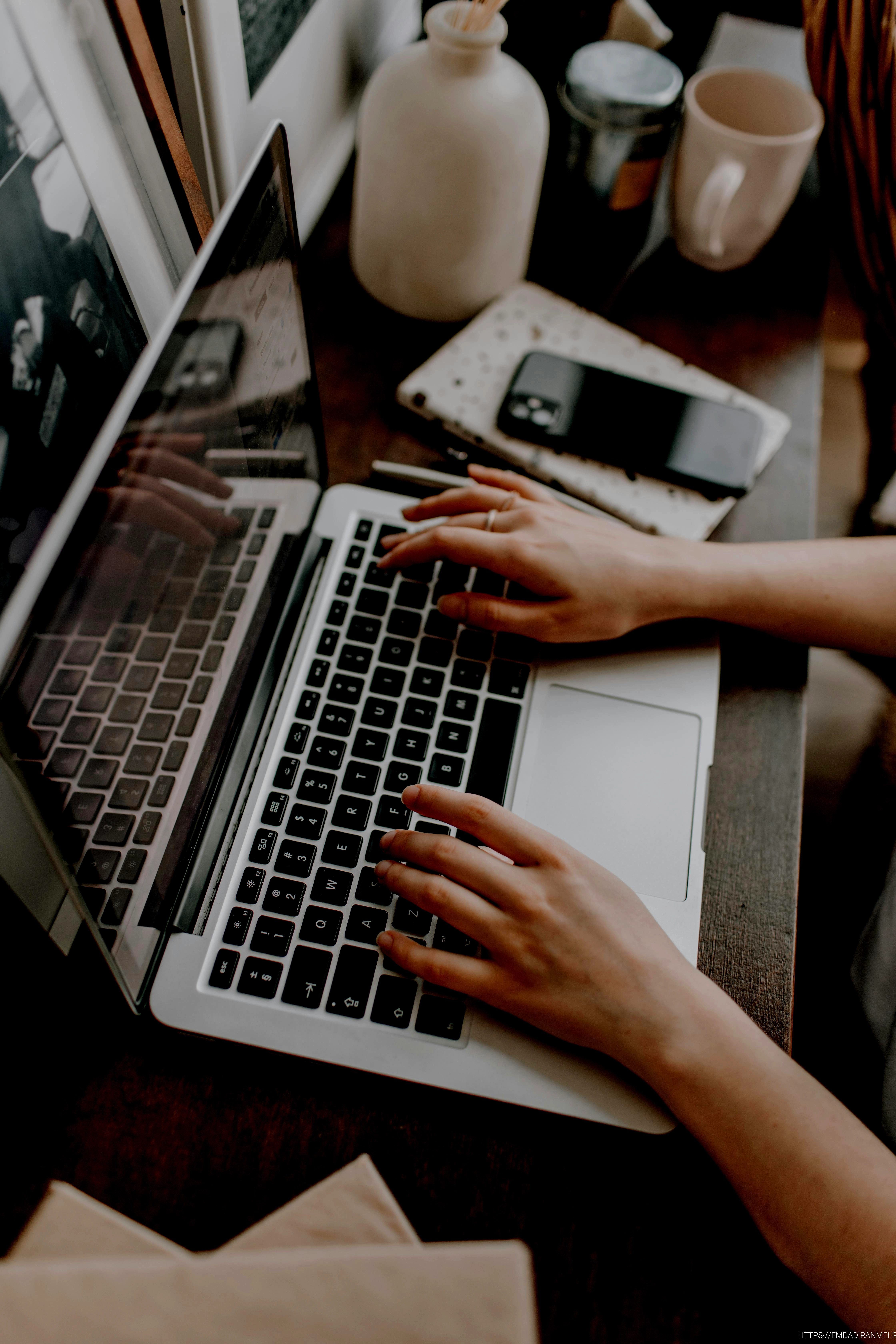 crop female freelancer using laptop at table at home